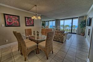 a dining room and living room with a glass table and chairs at Dunes of Panama in Panama City Beach