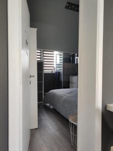 a white bedroom with a bed and a room with a window at Escale in Liège
