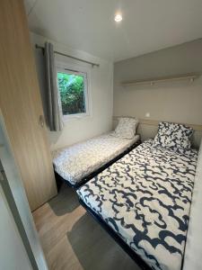 1 dormitorio con 2 camas y ventana en Mobil-Home au pied du Luberon, en La Roque-d'Anthéron