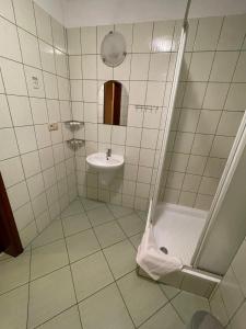 uma casa de banho com um chuveiro, um lavatório e um WC. em Hotel Omega em Ostrów Wielkopolski