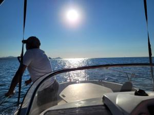 Ein Mann steht vor einem Boot im Wasser. in der Unterkunft F2 Saint-Aygulf vue mer, calme, proche Frejus in Saint-Aygulf