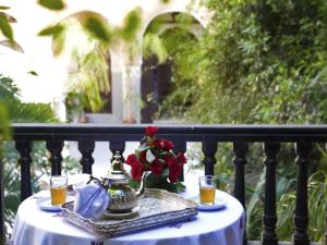 a table with a tea kettle and flowers on a balcony at Palais Shéhérazade & Spa in Fès