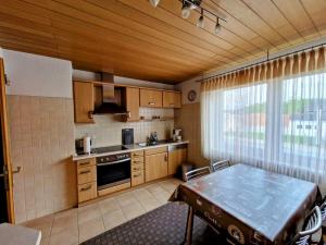 una cocina con armarios de madera y una mesa. en Ferienhaus Anni Rödental, en Rödental