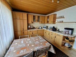 una cocina con armarios de madera y una mesa. en Ferienhaus Anni Rödental, en Rödental