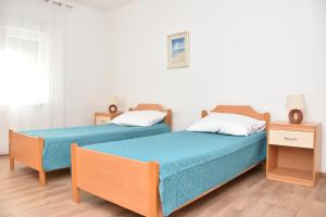 dwa łóżka siedzące obok siebie w pokoju w obiekcie Apartments Ivan w mieście Zadar