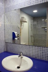 a bathroom with a sink and a mirror at Hotel Grecs in Roses