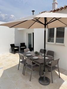 a table with an umbrella on a patio at Casa Maria João in Lagos