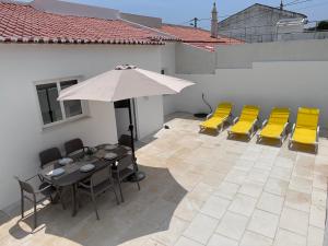 a patio with a table and chairs and an umbrella at Casa Maria João in Lagos