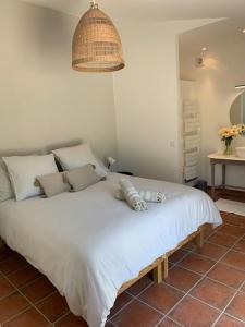una camera da letto con un grande letto bianco e una lampada di Mas de la Pivoine a Le Puy-Sainte-Réparade