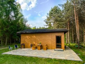 a small wooden cabin with a patio in the grass at Domek Letniczówka in Olsztynek