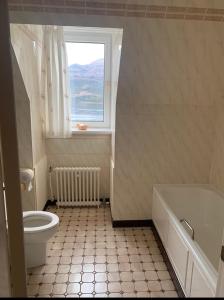 uma casa de banho com uma banheira, um WC e uma janela. em Lochalsh Hotel with Views to the beautiful Isle of Skye em Kyle of Lochalsh