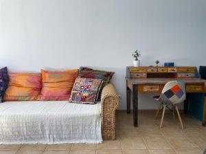 Camera con letto e scrivania con cuscini. di Cozy apartment with large terrace next to the pool a La Tejita