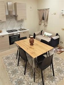 cocina y comedor con mesa de madera y sillas en Sicilia bedda, en Agrigento