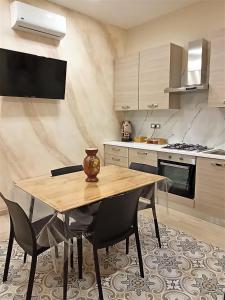 a kitchen with a wooden table and chairs at Sicilia bedda in Agrigento