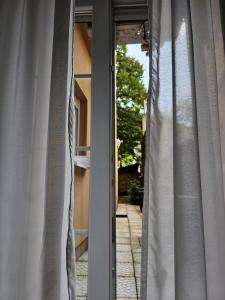 uma janela aberta com cortinas brancas numa casa em Poppy Apartments Zagreb (MINT) em Zagreb