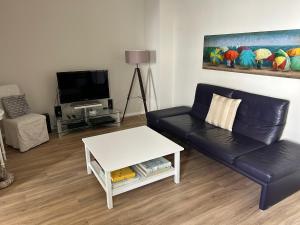 a living room with a black leather couch and a table at Ferienwohnung Ludwigslust in Ludwigslust