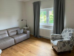 a living room with a couch and a chair and a window at Ferienwohnung Ludwigslust in Ludwigslust