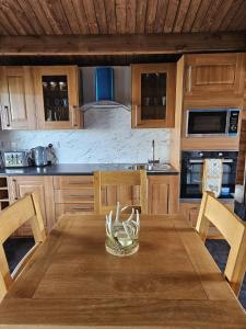 uma cozinha de madeira com uma mesa e cadeiras de madeira em Hillhaven Lodge em Inverness