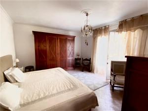 1 dormitorio con cama y lámpara de araña en viilla D Aurus, en Vallauris