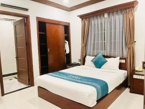 a bedroom with a bed and a window at IBIZA Danang Riverfront Hotel in Danang
