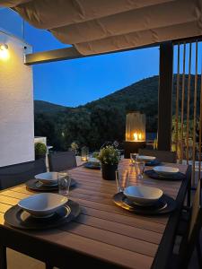 una mesa de madera con platos y copas de vino en una terraza en Golden residence with heated pool, en Vinišće