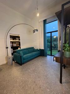uma sala de estar com um sofá verde e uma grande janela em Mille912 relais em Piano di Sorrento