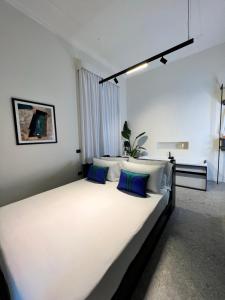 um quarto com uma grande cama branca com almofadas azuis em Mille912 relais em Piano di Sorrento