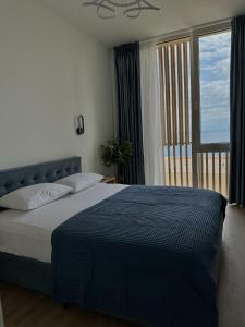 a bedroom with a bed and a large window at Sapphire Residence Green Coast in Palasë