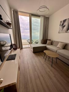 een woonkamer met een bank en een tafel bij Sapphire Residence Green Coast in Palasë