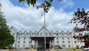 a large white building with an american flag on top at Holiday Inn Express & Suites - Lincoln East - White Mountains, an IHG Hotel in Lincoln
