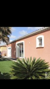una casa con una palmera delante en Villa Leprevost, en Béziers