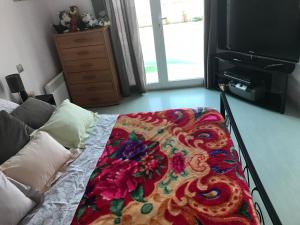 ein Schlafzimmer mit einem Bett mit einer bunten Decke darauf in der Unterkunft Villa Leprevost in Béziers