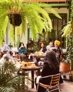 um grupo de pessoas sentadas em mesas em um restaurante em Hotel Posada de San Agustin em Tunja