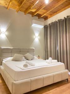 a bedroom with a large white bed in a room at Vila Arial in Vlorë