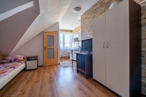 an attic bedroom with a bed and a kitchen at Pod Jedynkami in Władysławowo