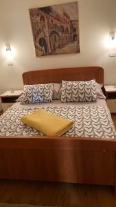 a wooden bed with a yellow pillow on it at Vila Bianca in Umag