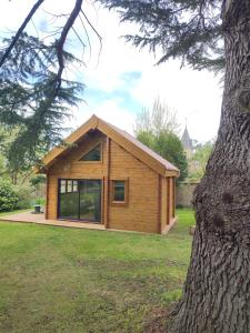 a log cabin with a large window and a tree at L'ETAPE PARIS-FONTAINEBLEAU in Pringy
