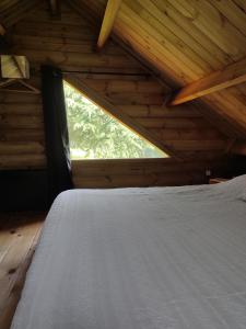 a bed in a wooden room with a window at L'ETAPE PARIS-FONTAINEBLEAU in Pringy