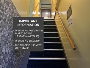 a stairway with a sign that reads important information at Hotel Jesse in Amsterdam