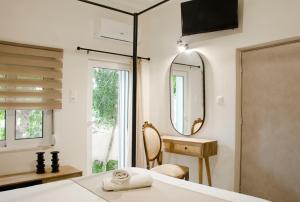 1 dormitorio con espejo, escritorio y silla en Sia's Sea House, en Almyrida