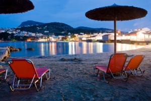 two chairs and an umbrella on a beach at Sia's Sea House in Almyrida