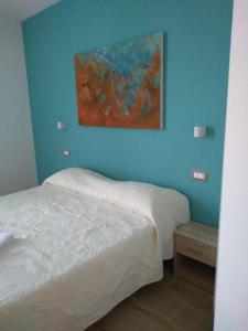 ラ・スペツィアにあるAffittacamere Da Euroのベッドルーム1室(ベッド1台付)が備わります。壁には絵画が飾られています。