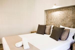 een slaapkamer met een wit bed met 2 kussens bij Sia's Sea House in Almirida