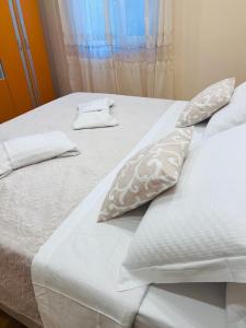 a bed with white sheets and pillows on it at IMPERIUM DK VILLA 