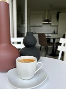 eine Tasse Kaffee auf einem Tisch mit einer Vase in der Unterkunft Wanderlust Petrisberg - Studio 54 in Trier