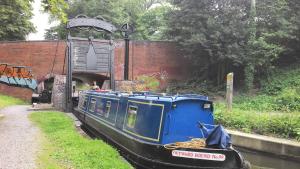a blue boat is going through a tunnel at Narrowboat canal holiday from19th august in Aldermaston