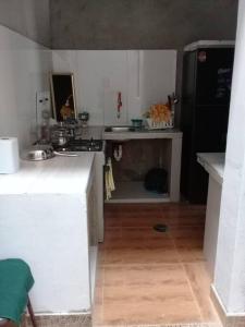 Elle comprend une petite cuisine avec un réfrigérateur noir et du parquet. dans l'établissement CASA TALLÁN 2 habitaciones wifi Cocina baño privado Jr Junin 263 barrio norte Piura, à Piura