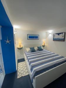 a bedroom with a large bed with blue and white sheets at Casa Nadip in Ustica
