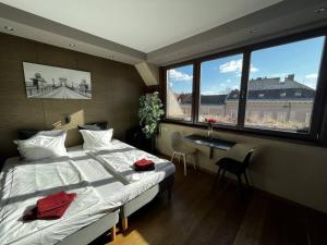 1 dormitorio con 1 cama, escritorio y ventanas en Bright/sunny/apartment w/shared rooftop terrace 360 view, en Budapest
