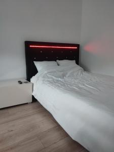 - une chambre avec un lit blanc et une tête de lit rouge dans l'établissement Chambre privé dans une maison avec terrasse et jardin salles de bain partagées, à Lille